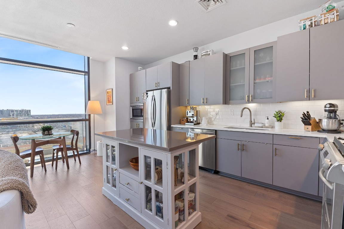 555 East 5th Street, Unit 817 Austin, TX 78701 - Photo 4 of 39 a kitchen with refrigerator cabinets table and chairs