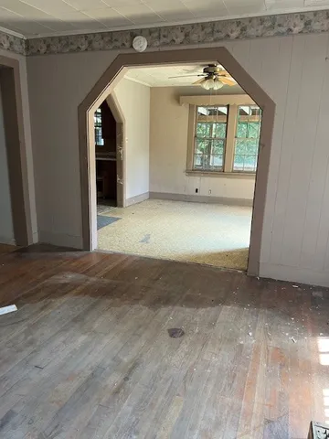 a view of a hallway with wooden floor and a window