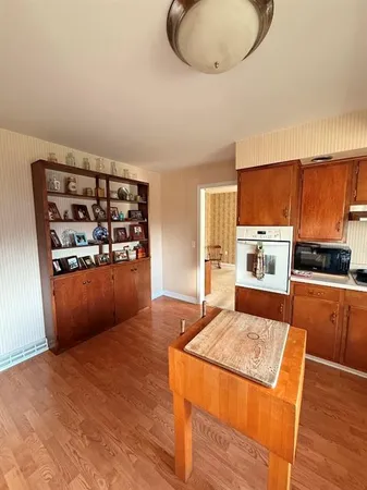 a kitchen with stainless steel appliances granite countertop a refrigerator a stove and a wooden cabinets