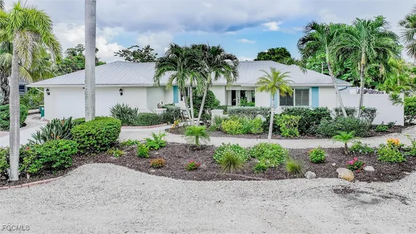 a view of a house with a yard and potted plants