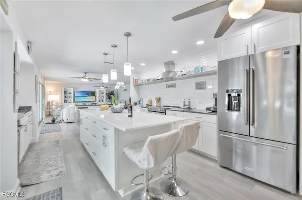 a kitchen with stainless steel appliances kitchen island granite countertop a refrigerator and a stove top oven