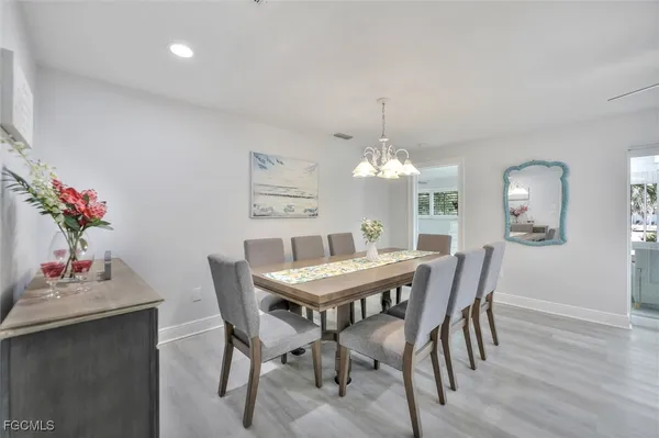 a view of a dining room with furniture a chandelier and wooden floor