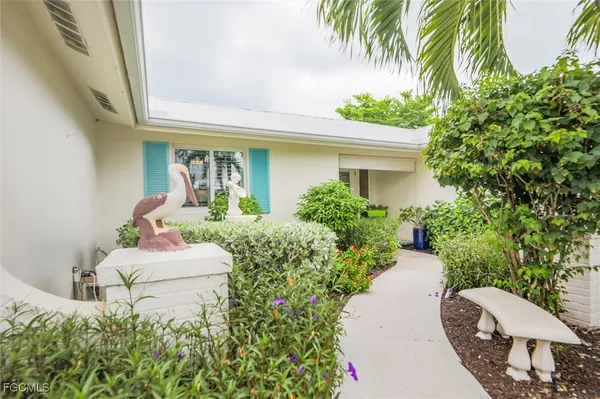 a front view of a house with a yard and potted plants