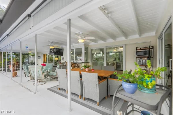 a view of a patio with dining table and chairs potted plants