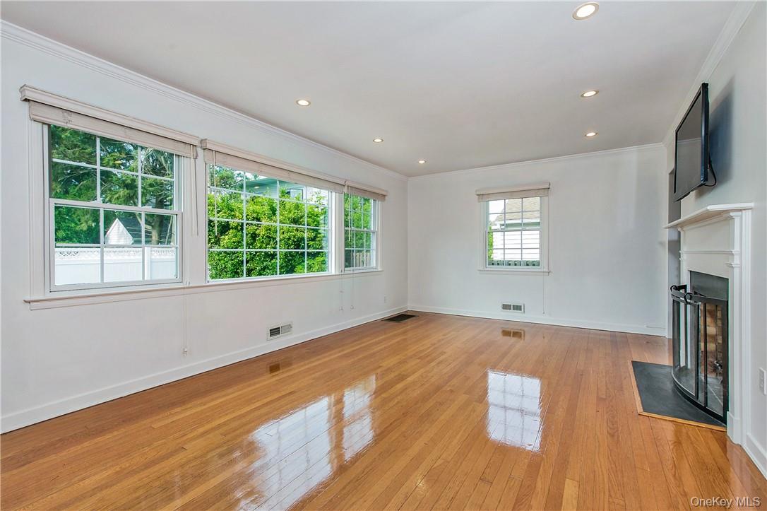 74 Dearborn Avenue Rye, NY 10580 - Photo 3 of 17 Light-filled Living Room with walls of windows and wood burning fireplace.