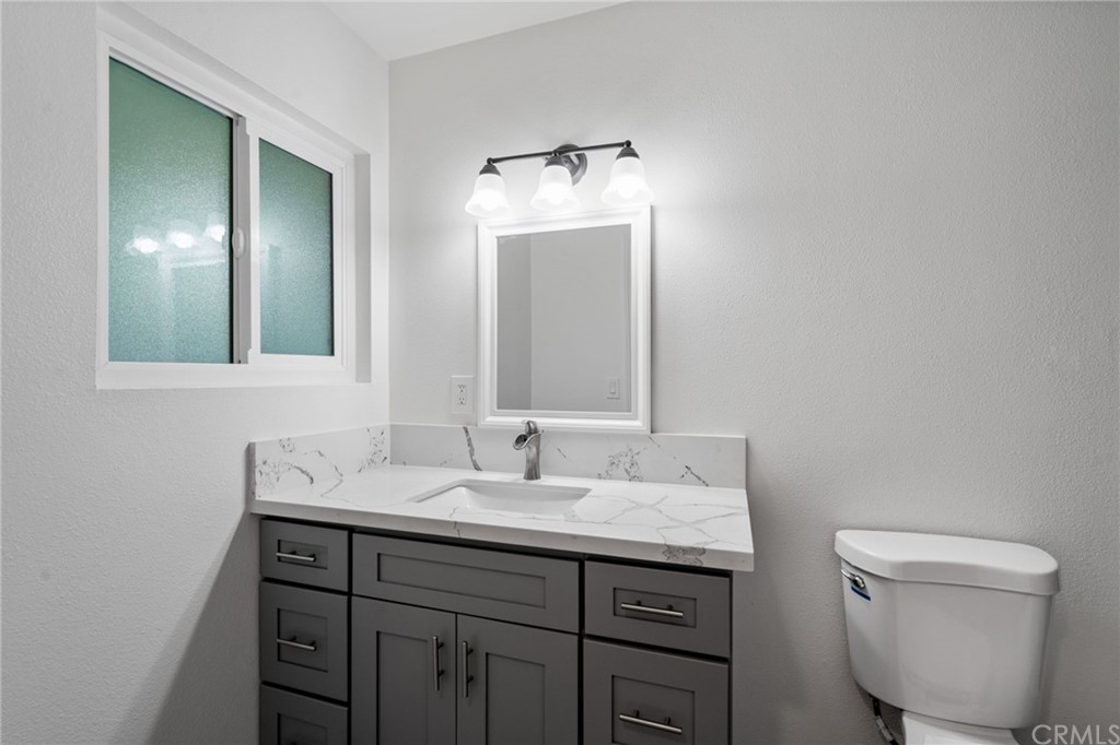 19309 Belshaw Avenue Carson, CA 90746 - Photo 15 of 40 a bathroom with a toilet sink and mirror