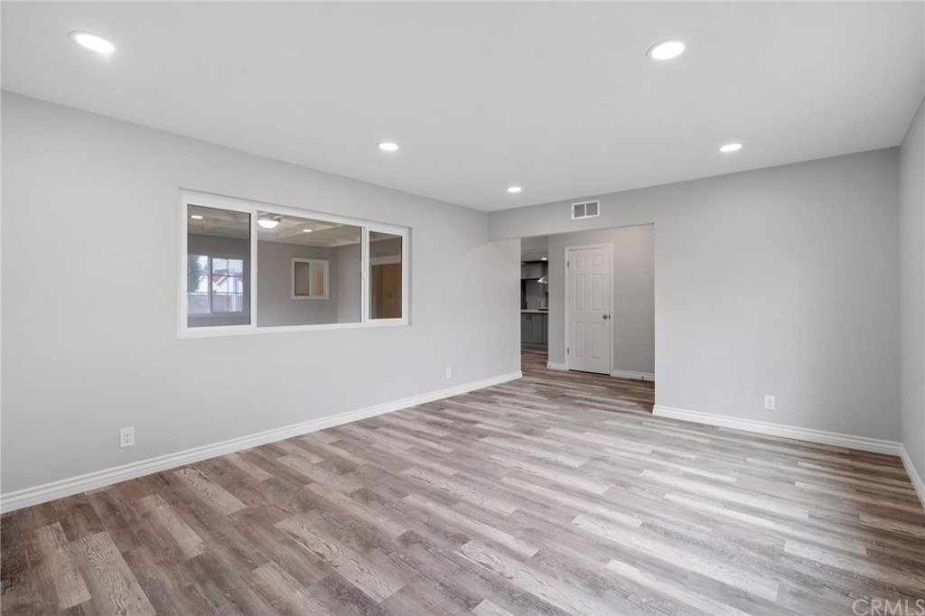 19309 Belshaw Avenue Carson, CA 90746 - Photo 7 of 40 a view of an empty room with wooden floor and a window