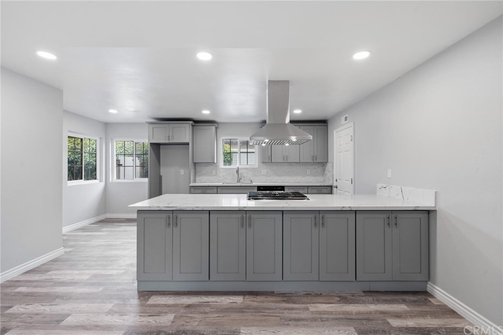 19309 Belshaw Avenue Carson, CA 90746 - Photo 10 of 40 a kitchen with stainless steel appliances granite countertop a sink a stove and a wooden floors