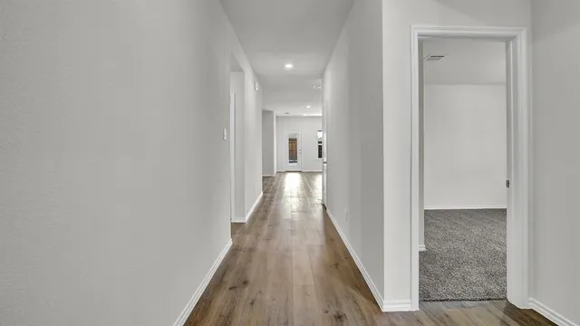 a view of a hallway with wooden floor