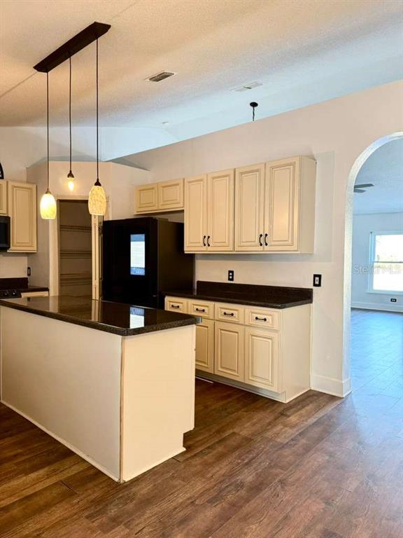 7132 Landmark Drive Spring Hill, FL 34606 - Photo 4 of 14 a kitchen with stainless steel appliances kitchen island granite countertop a stove a sink and white cabinets with wooden floor