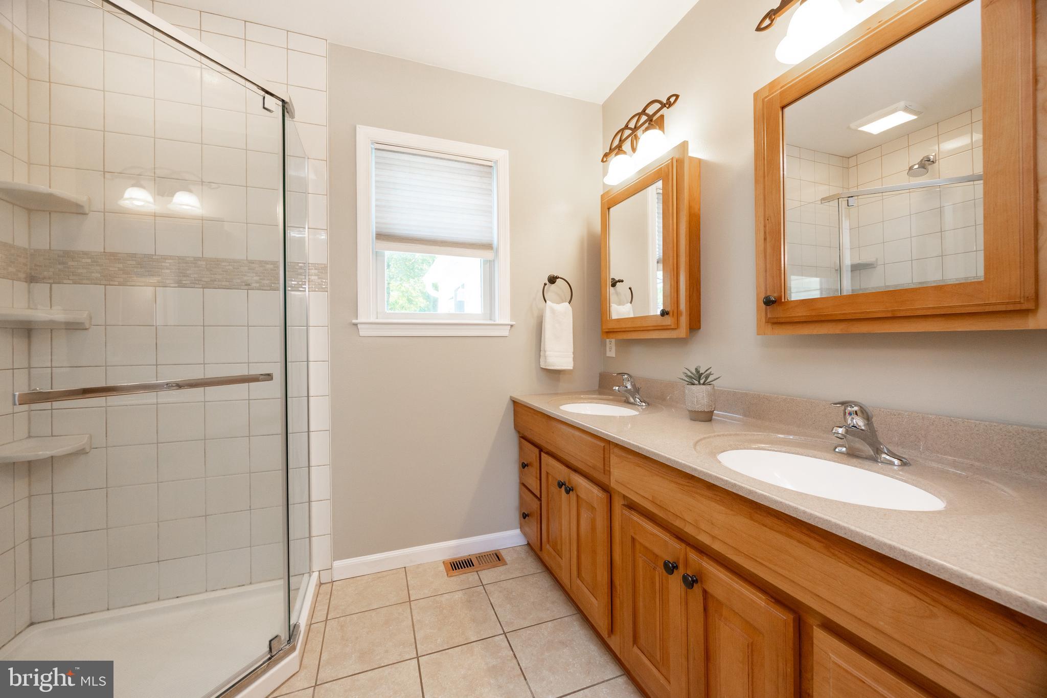 402 Concord Avenue Exton, PA 19341 - Photo 20 of 39 a bathroom with a double vanity sink a mirror and a shower