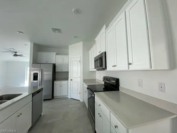 a kitchen with granite countertop a refrigerator and a stove