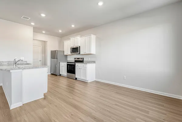 a view of kitchen with microwave oven a sink and dishwasher with wooden floor