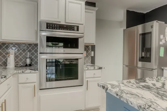 a kitchen with granite countertop a stove and a refrigerator