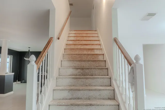 a bedroom with a bed a desk and chair with the potted plant