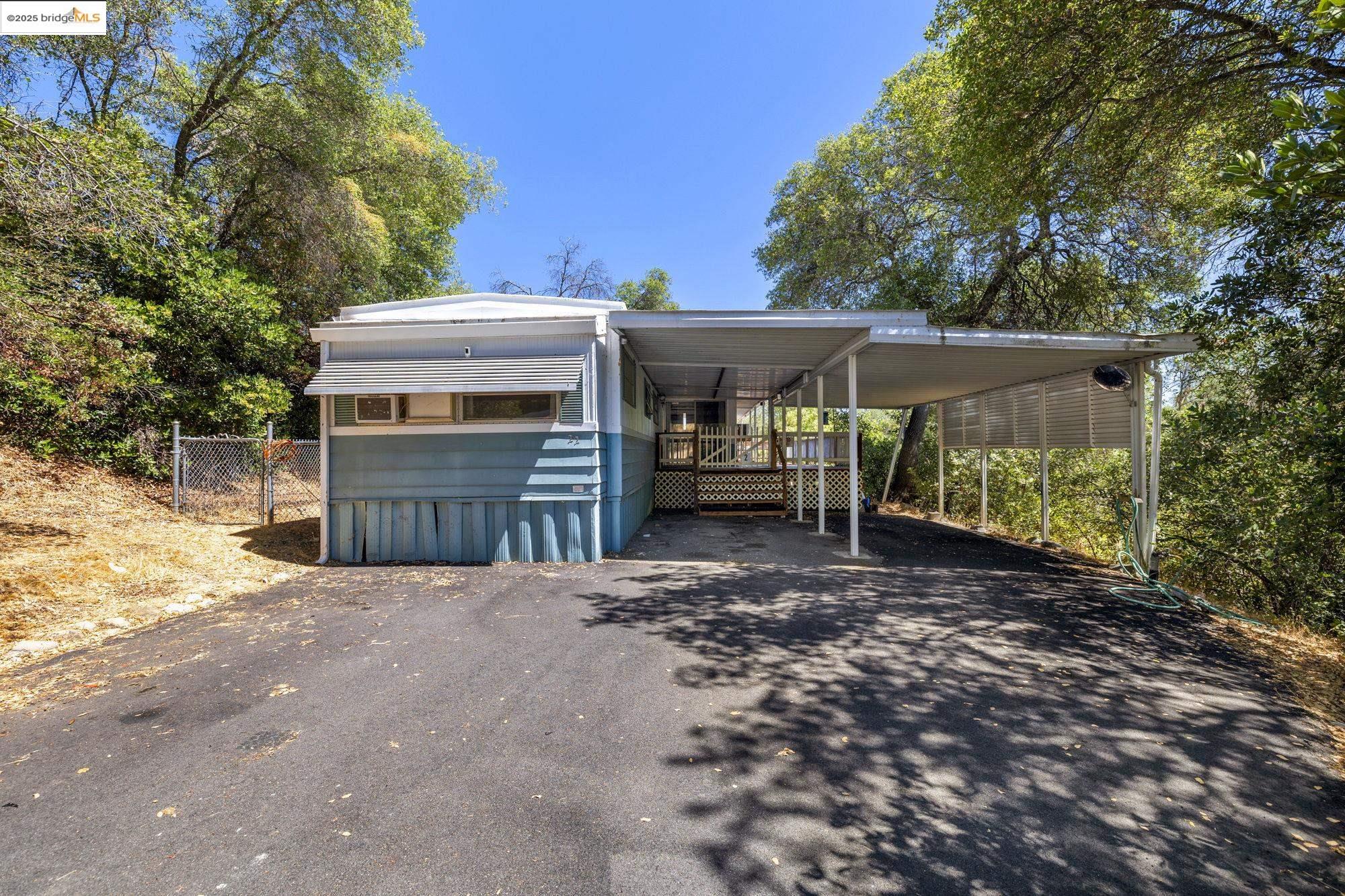 View of front facade featuring a carport and driveway