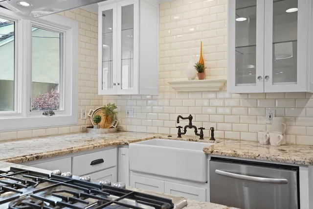 a kitchen with stainless steel appliances granite countertop a sink a stove and a refrigerator