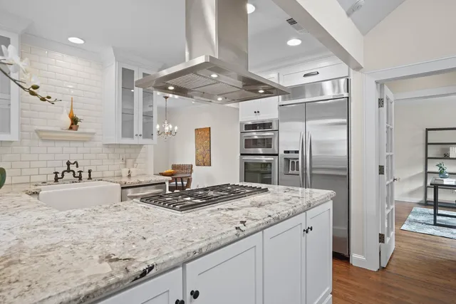 a spacious bedroom with a large bed and a chandelier