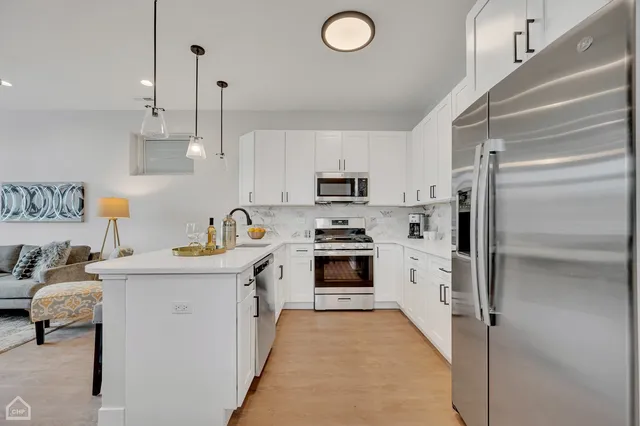a kitchen with white cabinets and stainless steel appliances