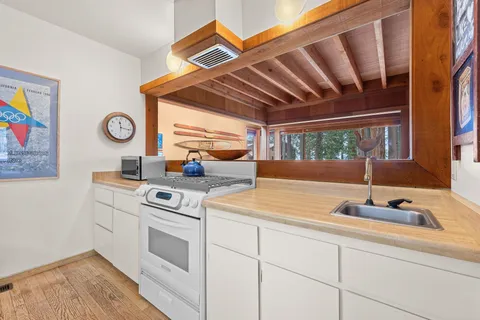 a kitchen with a stove cabinets and a wooden floor