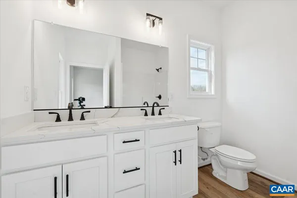 a bathroom with a granite countertop toilet sink and mirror