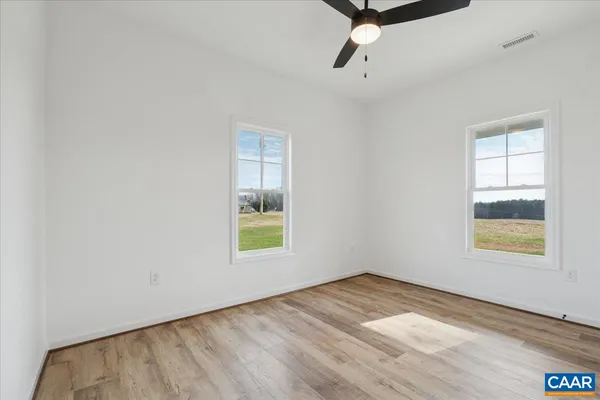 an empty room with a window and a ceiling fan