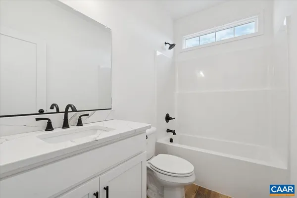 a bathroom with a sink toilet vanity and shower