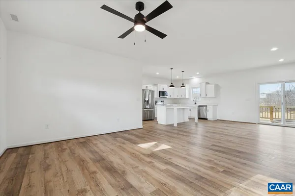 a view of an empty room with window and wooden floor