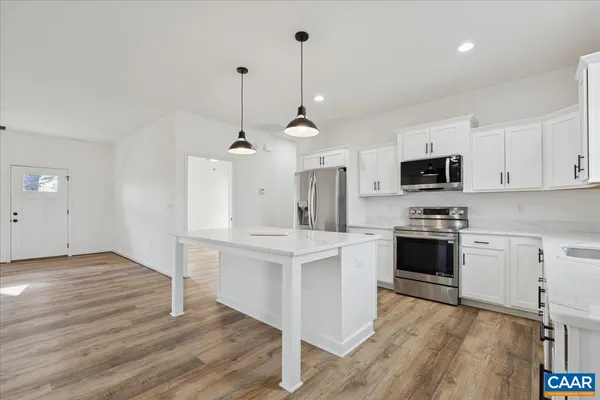 a kitchen with white cabinets and stainless steel appliances