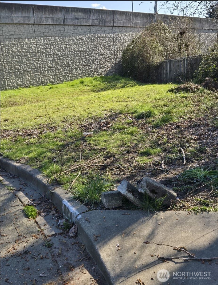 a view of a yard with a wooden fence