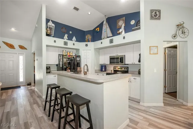 a kitchen with stainless steel appliances kitchen island granite countertop a refrigerator and microwave