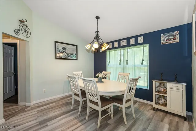 a dining room with furniture a chandelier and wooden floor