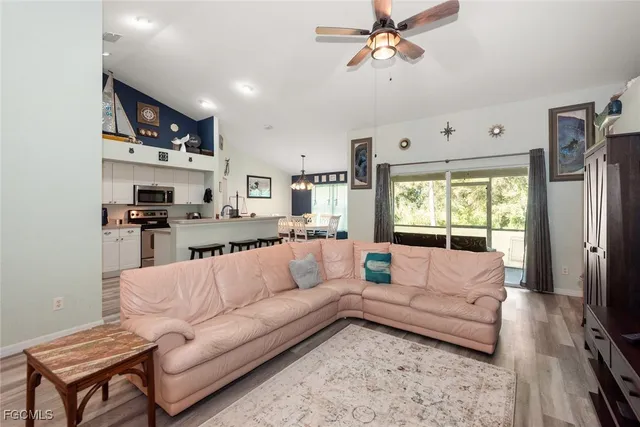 a view of living room kitchen with stainless steel appliances granite countertop furniture and a couch