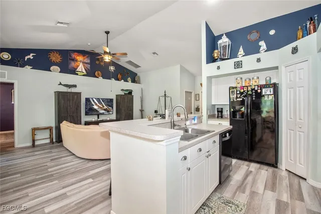 a large white kitchen with a lot of counter space and wooden floor