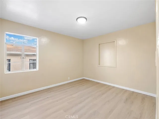 a view of a room that has wooden floor and windows in it