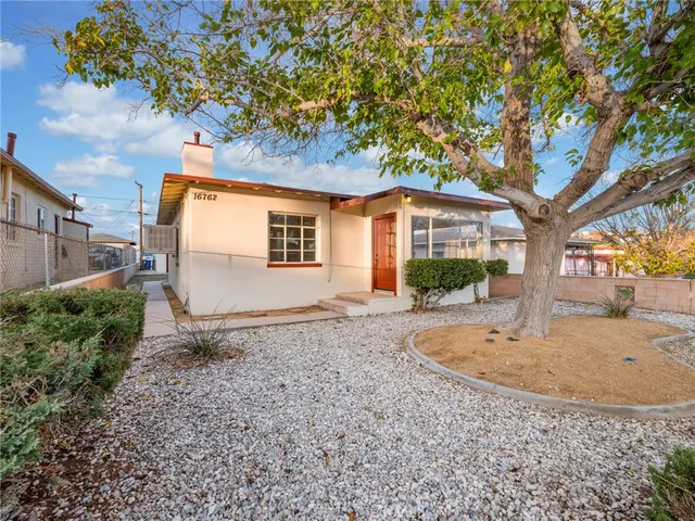a view of a house with a tree in the yard