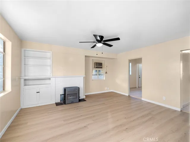 a view of a livingroom with wooden floor and a ceiling fan