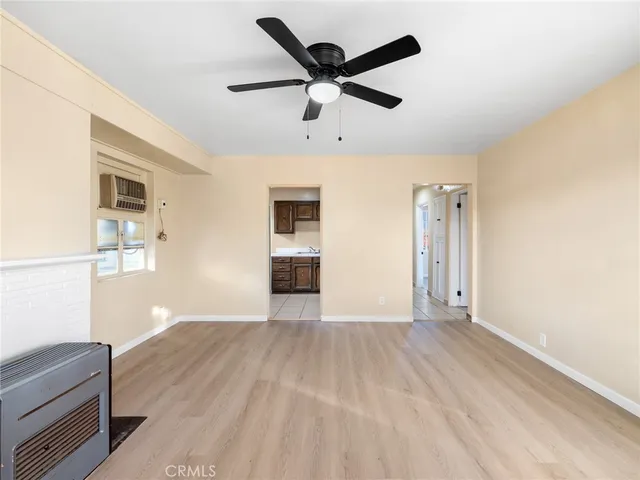 a view of an empty room with window and wooden floor