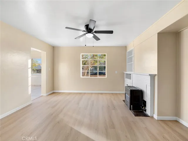 an empty room with windows fireplace and windows