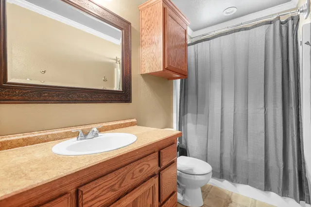 a bathroom with a sink a toilet and a mirror