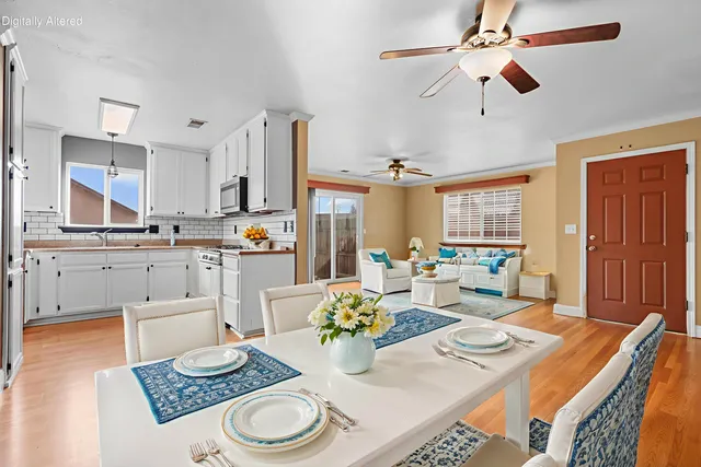 a kitchen with a table chairs and white cabinets
