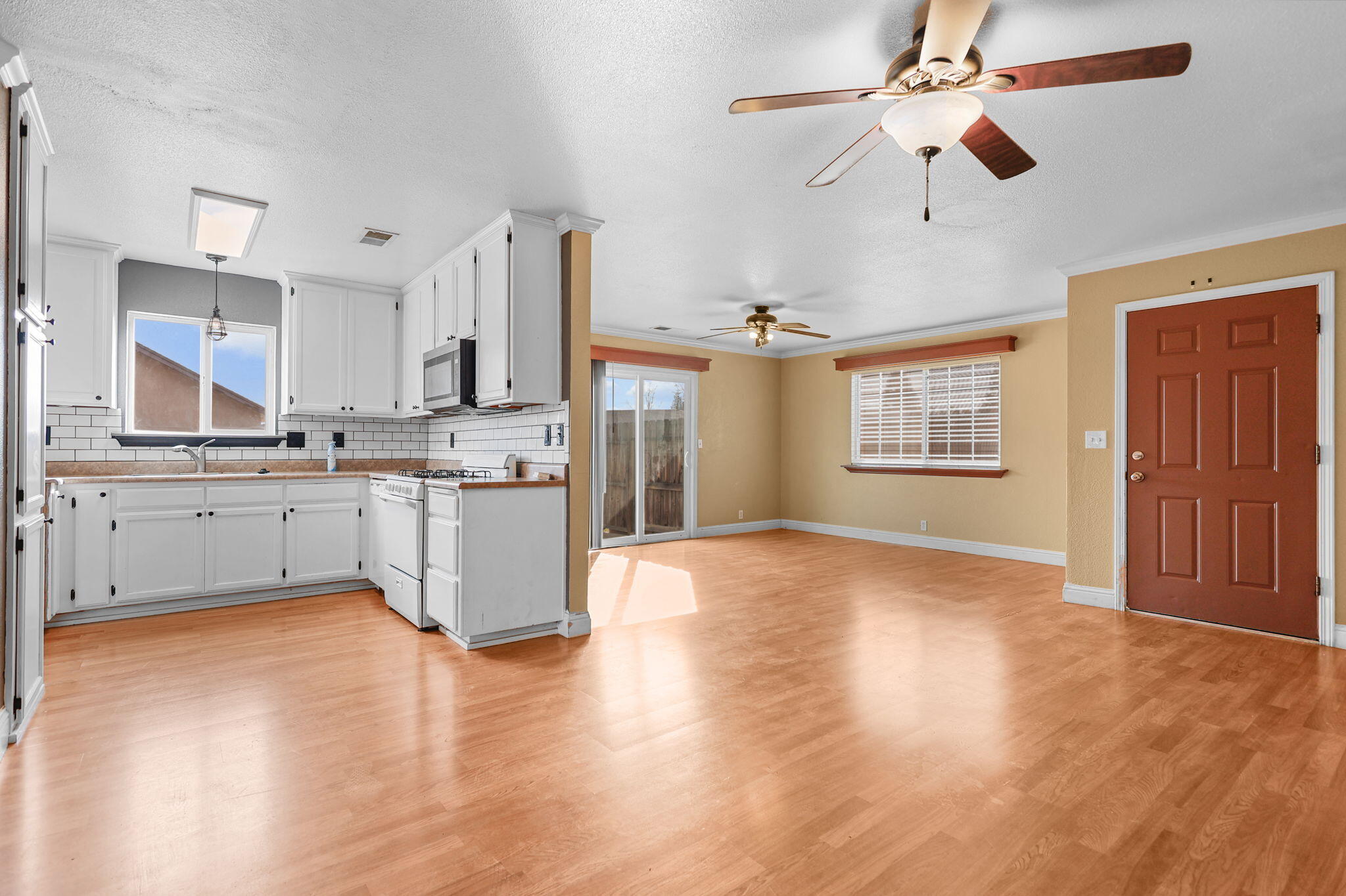 2180 Gentry Way Red Bluff, CA 96080 - Photo 6 of 27 a kitchen with stainless steel appliances a stove a sink dishwasher a refrigerator and white cabinets with wooden floor