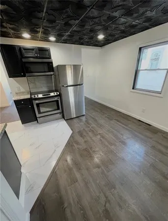 a kitchen with a refrigerator and white cabinets