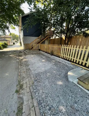 a view of a yard with wooden fence