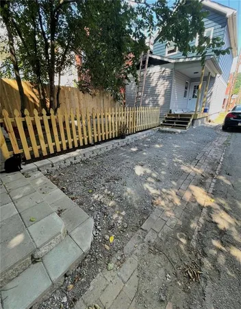 a view of a street with wooden fence