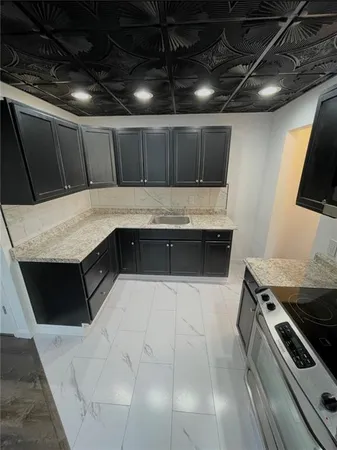 a kitchen with a sink a stove and a microwave