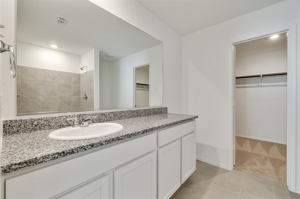 2809 Ozark Circle Little Elm, TX 75068 - Photo 23 of 28 a bathroom with a granite countertop sink and a mirror