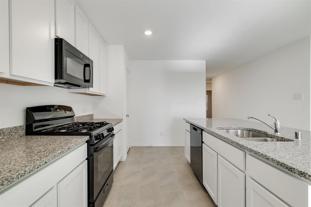 2809 Ozark Circle Little Elm, TX 75068 - Photo 6 of 28 a kitchen with stainless steel appliances granite countertop a sink and a stove