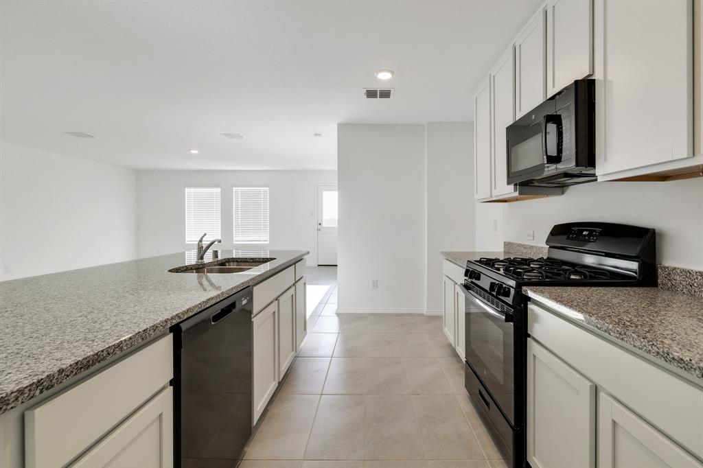 2809 Ozark Circle Little Elm, TX 75068 - Photo 7 of 28 a kitchen with stainless steel appliances granite countertop a sink and a stove