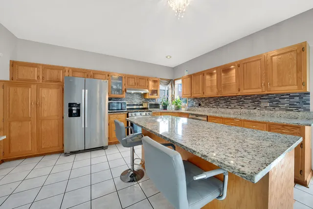 a kitchen with stainless steel appliances granite countertop a refrigerator a stove and sink